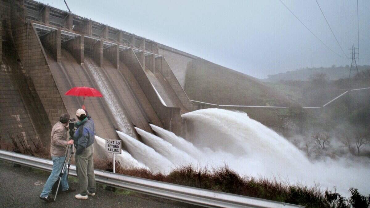 A video crew records water being released from Folsom Dam at a high rate on Jan. 1, 1997, during an El Niño winter.